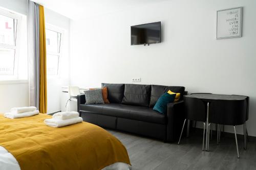 a living room with a black couch and a table at Almada Downtown 101 in Porto