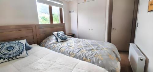 1 dormitorio con cama y ventana en Excelente vista a pasos del lago, en Puerto Varas en Puerto Varas