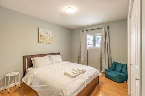 1 dormitorio con 1 cama y 1 silla azul en NN - The Woodland - Yellowknife 3-bed 1-bath, en Yellowknife