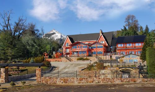 um grande edifício vermelho com uma montanha ao fundo em Le Château em San Carlos de Bariloche