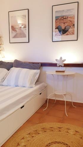a bedroom with a bed with a desk and two pictures at Estúdio na Falésia in Albufeira