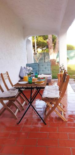 a patio with a table and chairs and a couch at Estúdio na Falésia in Albufeira