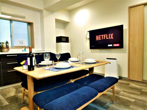 a dining room with a table and a tv at GLANZ KEI Kyoto Station in Kyoto