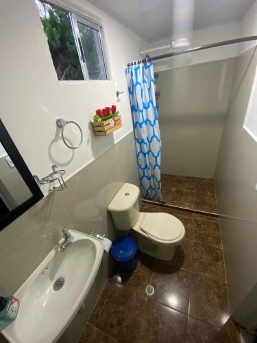 a bathroom with a toilet and a tub and a sink at Finca Villa Maju in Papagalleros