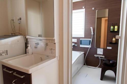 a bathroom with a sink and a bath tub at GLANZ KEI Kyoto Station in Kyoto