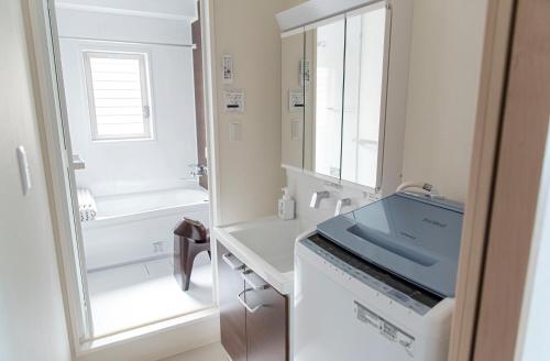 a white bathroom with a sink and a mirror at GLANZ KEI Kyoto Station in Kyoto