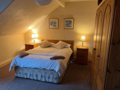 een slaapkamer met een bed met 2 nachtkastjes en 2 lampen bij Cosy Town House in Belfast