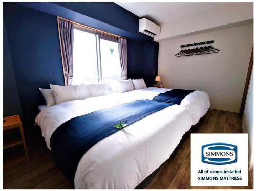 a bedroom with a large bed with blue walls at GLANZ KEI Kyoto Station in Kyoto