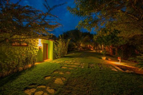 a walkway in the yard of a house at night at Pousada Mangabeiras in Ilha de Boipeba