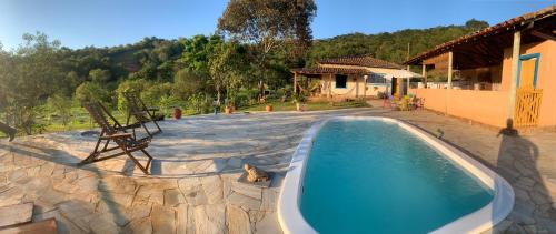 una piscina en un patio con una casa en Sítio Santa Rita, en Prados