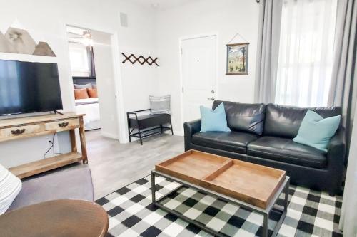 uma sala de estar com um sofá de couro preto e uma mesa de centro em Vacation Home Minutes From Downtown, Great For Families em Ogden
