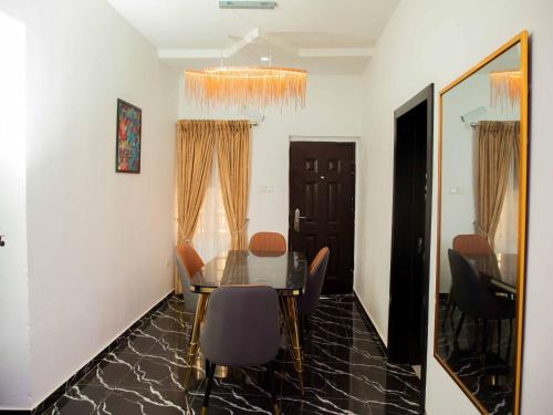 a dining room with a table and chairs and a mirror at Delight Apartments in Lagos
