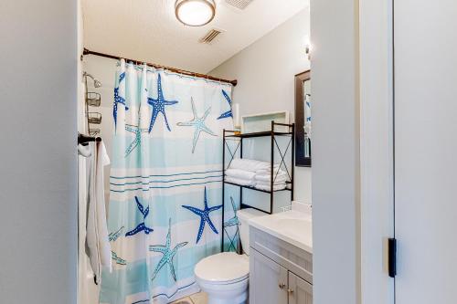 a bathroom with a shower curtain with blue starfish at Gulf Island 412 in Navarre