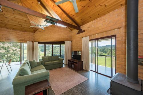 a living room with a couch and a tv and windows at Clarendon Forest Retreat in Possum Brush