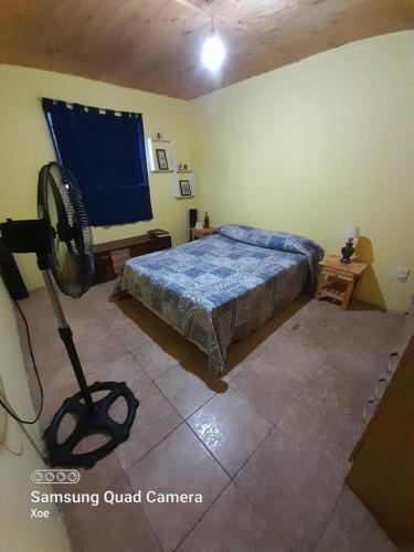 1 dormitorio con 1 cama y ventilador en Alojamiento Campeche en Cavalango