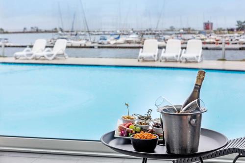 a tray of food and a bottle of wine next to a pool at Best Western Hotel Corallen in Oskarshamn