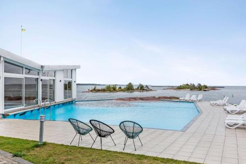 a swimming pool with two chairs next to a house at Best Western Hotel Corallen in Oskarshamn