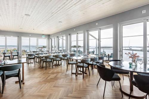 a dining room with tables and chairs and windows at Best Western Hotel Corallen in Oskarshamn