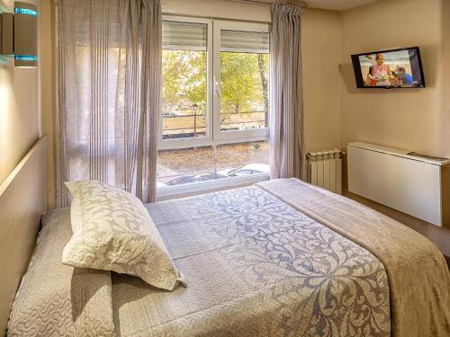 a bedroom with a bed in front of a window at Hostal Real Aranjuez in Aranjuez