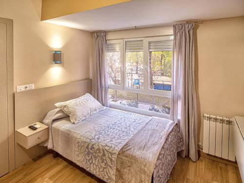 a small bedroom with a bed and a window at Hostal Real Aranjuez in Aranjuez