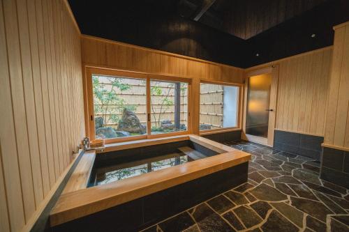 Takahashiにある城下町一棟貸し旅館　天籟の窓付きの客室で、ジャクジータブが備わります。