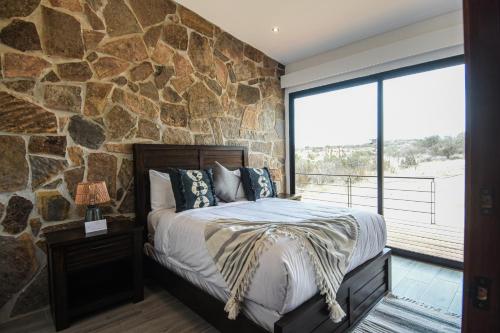 a bedroom with a stone wall and a bed at Casa Brisa Chivato in Chivato