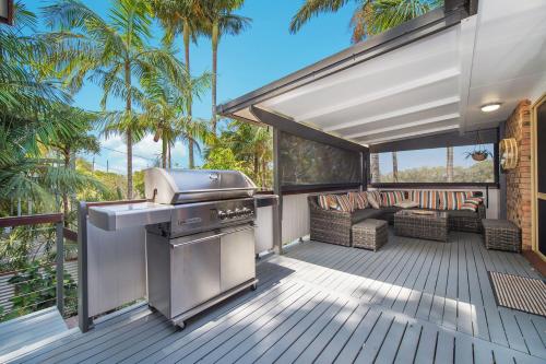 an outdoor kitchen with a grill and a patio at Seaclusion in Bonny Hills