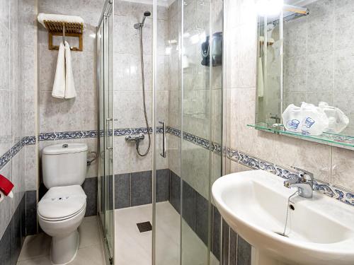 a bathroom with a toilet and a sink and a shower at Hostal Real Aranjuez in Aranjuez
