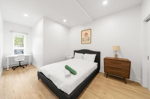 a bedroom with a bed and a table and a chair at Stonewall Suites in Montréal