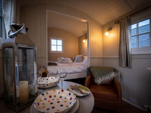 ein kleines Zimmer mit einem Bett und einem Tisch mit einem Teller in der Unterkunft The Pleasant Hut at MountPleasant Farm in Ulverston