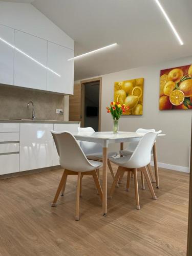 a kitchen with a white table and chairs in a room at Apartamento D'As Baladas in O Grove