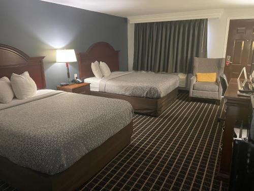 a hotel room with two beds and a chair at Econo Lodge Jefferson Hills Hwy 51 in Clairton