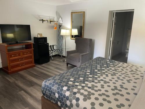 a bedroom with a bed and a television and a chair at Econo Lodge Jefferson Hills Hwy 51 in Clairton