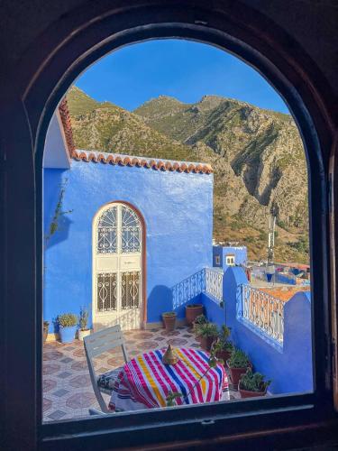 a view through a window of a blue building at Casa Sanae in Chefchaouene