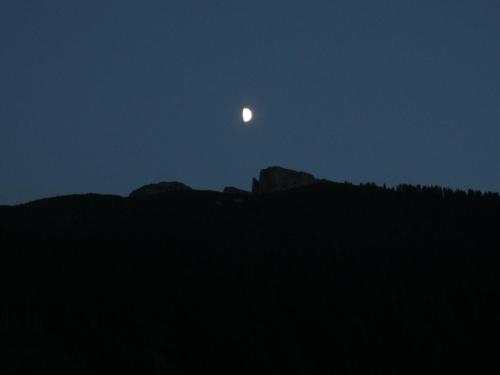 a moon rising over the mountains at night at Hanserhof in Zell am Ziller