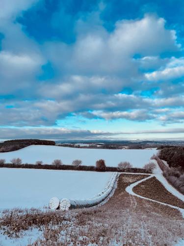 a road in a field with snow on the ground at East Learmouth Lakeside Lodges in Cornhill-on-tweed