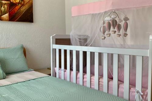a baby crib with a pink and white crib at 3 Quartos Melhor Valor do Df próximo ao Aeroporto e Plano in Brasilia