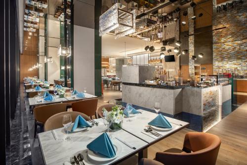 a restaurant with tables and chairs and a counter at Crowne Plaza Zhengzhou High Tech Zone by IHG in Zhengzhou