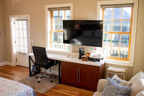 a room with a desk with a television on a wall at 14 1/2 St. George Street in Saint Augustine