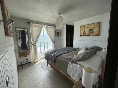 a bedroom with a bed and a large window at Mirada al Mar in Matanzas