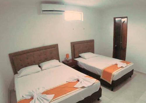 2 bedden in een hotelkamer met 2 slaapkamers bij Hotel PaloQuemao in Quibdó