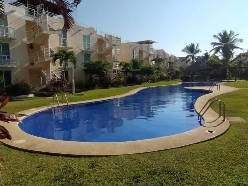 uma grande piscina em frente a alguns edifícios de apartamentos em Departamento amplio y amueblado en Marina Diamante em Acapulco