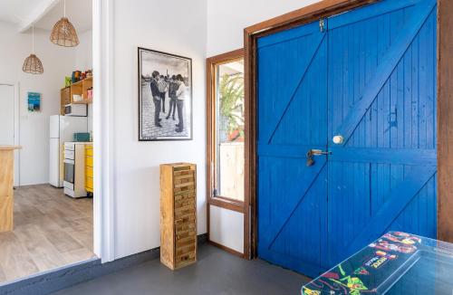een blauwe deur in een kamer met een keuken bij The Piccolo Shack in Gracetown
