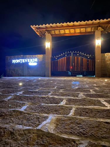 a building with a stone patio at night at Glamping Monteverde San gil in San Gil