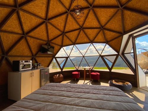 een grote kamer met een bed en een groot raam bij Glamping Monteverde San gil in San Gil