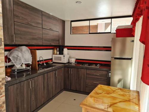 een keuken met houten kasten en een roestvrijstalen koelkast bij Casa Campo El Marquez in Jauja