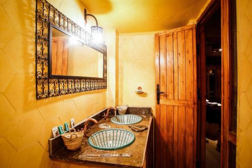 łazienka z 2 umywalkami i lustrem w obiekcie Dar marco polo w mieście Arfud