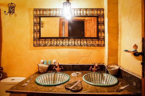 a bathroom with two sinks and a mirror at Dar marco polo in Erfoud