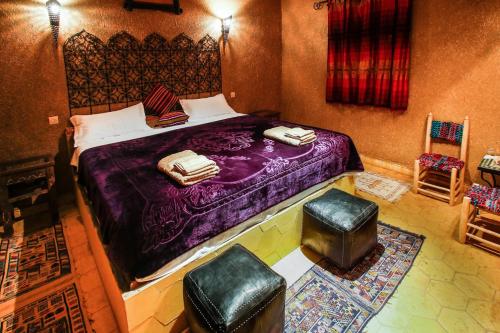 a bedroom with a large bed and two chairs at Dar marco polo in Erfoud