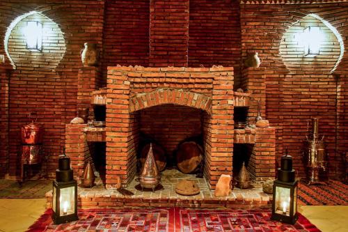 a brick room with a brick fireplace with bells at Dar marco polo in Erfoud